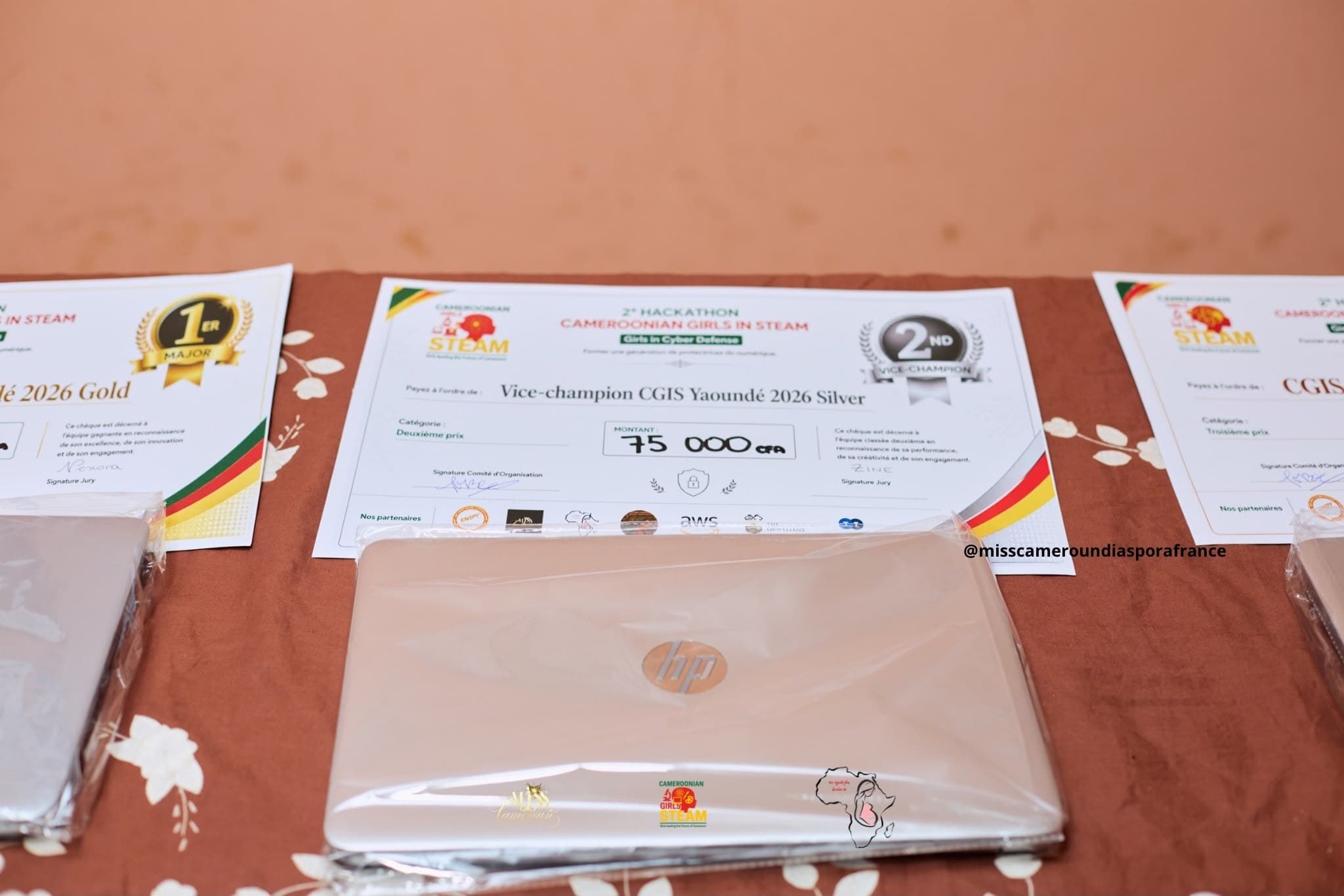 Les lots remis : PC portable et chèque factice sur une table